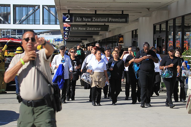 Passengers are directed outside Terminal 2 at Los Angeles International Airport on Friday Nov. 1, 2013, after shots were fired prompting authorities to evacuate a terminal and stop flights headed for the city from taking off from other airports.