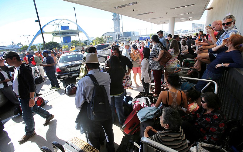 Passengers wait Friday for Los Angeles International Airport to reopen at Terminal 1. A gunman armed with a semi-automatic rifle opened fire at Los Angeles International Airport, killing a Transportation Security Administration employee and wounding two other people.