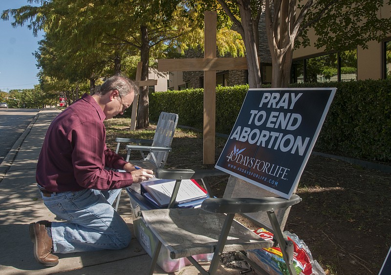 Lee Valerius adds his name to the list of people holding a vigil Friday outside of The Southwestern Women's Surgery Center in Dallas, following a federal appeals court ruling Thursday that allowed most of the state's new abortion restrictions to take effect. While Southwestern will still be able to perform abortions, twelve of the 32 clinics in the state that don't have doctors with admitting privileges at nearby hospitals will not be able to, though they can provide other services.