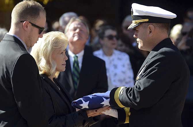 Patty Carpenter, left, receives the flag that was draped over her husband, astronaut Scott Carpenter's casket from U.S. Navy Rear Adm. Thomas Bond on Saturday, Nov. 2, 2013, in Boulder, Colo. Carpenter was the second American to orbit the Earth, following John Glenn. (AP Photo/The Daily Times Call, Lewis Geyer)