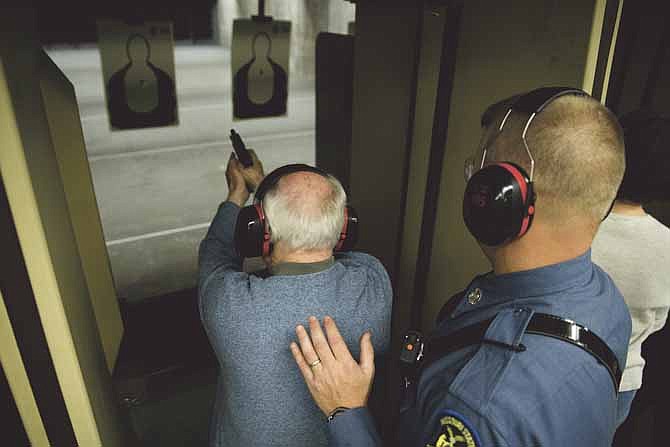 
Martin Beck, a participant in the Missouri State Highway Patrol's Community Alliance Program, fires a trooper's Glock 22 pistol during a shooting exercise at the patrol's gun range. Participants in the program are taught basic gun safety, as well as proper grip and stance for firing the weapons.