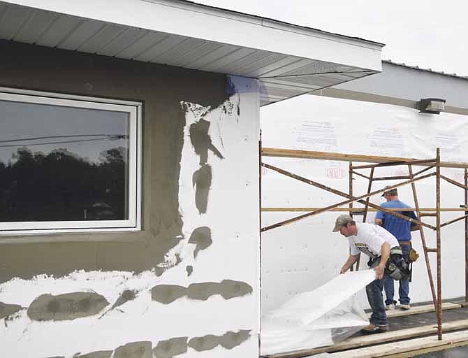 Remodeling is underway at the Legacy Room, formerly Donita's Banquet Center. At right, Pat Castrop and Brad Haller of Castrop Plastering work on the building's exterior.