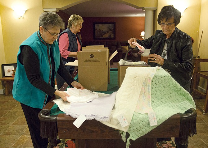 
Afghans for Angels co-coordinators Karen Fischer, Marylin Durk and Carol Galloway pack the last three boxes before shipping out more than 1,000 blankets to hospitals for their organization, which provides blankets for families who have lost babies through miscarriage, stillbirth or infant death. 