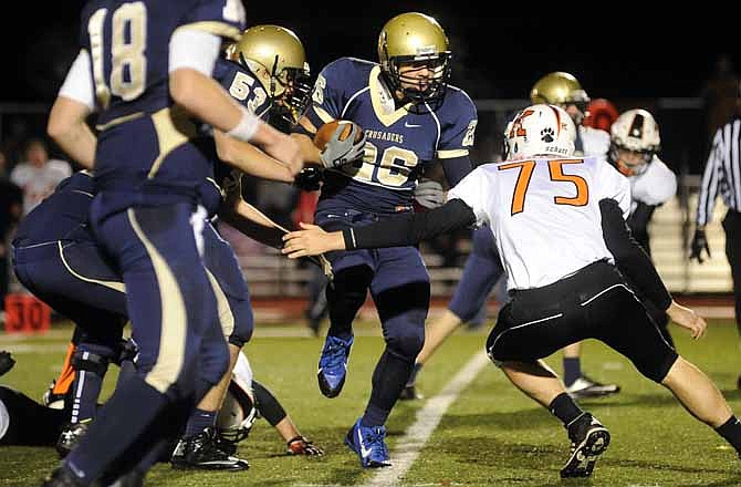 Helias running back Clayton Winter looks to pick up yardage as Alex Faddoul (18) and Nathan Raymer (53) look on Wednesday night at Adkins Stadium. Kirksville's Riley Johnson defends.