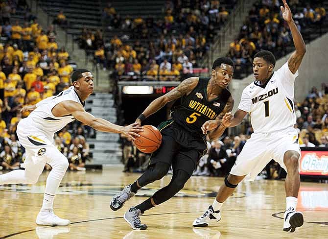 Southeastern Louisiana's JaMichael Hawkins, center, has the ball knocked away by Missouri's Jordan Clarkson, left, as he tries to drive past Wes Clark, right, during the second half of an NCAA college basketball game Friday, Nov. 8, 2013, in Columbia, Mo. Missouri won 89-53.