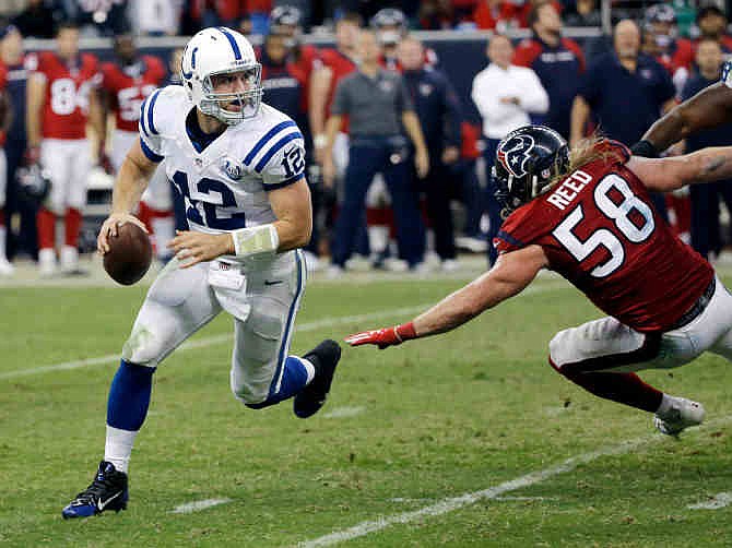 Indianapolis Colts' Andrew Luck (12) is pursued by Houston Texans' Brooks Reed (58) as he looks to pass during the third quarter of an NFL football game Sunday, Nov. 3, 2013, in Houston. 