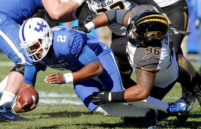 Kentucky quarterback Jalen Whitlow (2) is sacked by Missouri's Lucas Vincent (96) during the second quarter of an NCAA college football game, Saturday, Nov. 9, 2013, in Lexington, Ky. 
