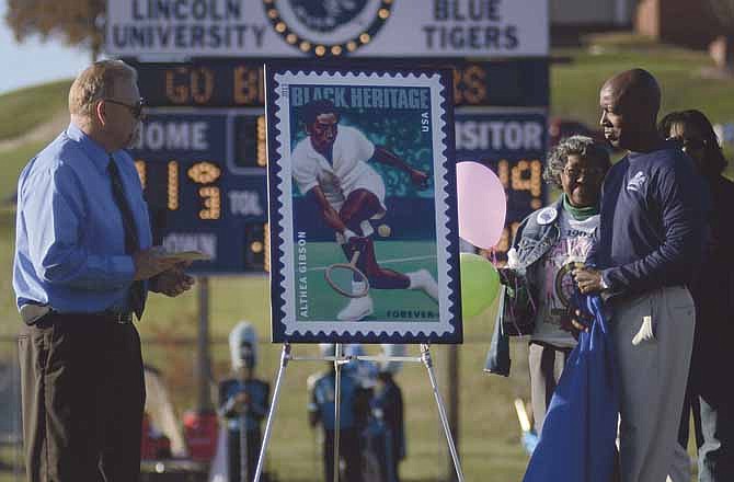 Jefferson City Postmaster Donald Knoth, left, and Lincoln University President Kevin Rome unveil a United States Postal Service stamp commemorating former Lincoln University instructor and professional tennis player Althea Gibson during Saturday's game against Northeastern State in Jefferson City.