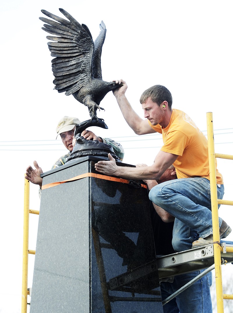Danny Seifert, right, and Hank Stratman set the four-foot bronze eagle atop the nine-foot obelisk, the centerpiece of the new Freedom Corner located in the island between East McCarty and East High streets. Seifert works for Carved in Stone along with Steve Walther, behind Seifert, put the pieces of granite  over the steel frame to form the pedestal on which the statue rests. The site will be dedicated at a 2 p.m. ceremony today.
