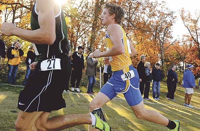Fatima sophomore Hunter Hennier overtakes College Heights Christian's Ryan Beaver on the outside near the two-mile mark in the Class 2 boys race Saturday at the Oak Hills Golf Center in Jefferson City.
