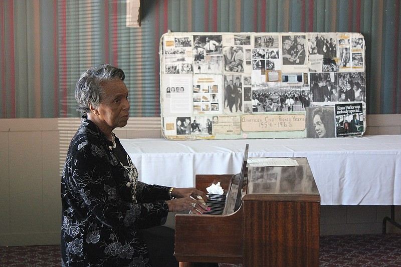 As patrons fill the Sir Winston's banquet room, Delores Lawson plays piano music amid a backdrop of Civil Rights Movement photographs for the Fulton NAACP and Youth Life Improvement Association's senior citizens holiday dinner. In addition to background music as people entered, Lawson started off the program with "Battle Hymn of the Republic."