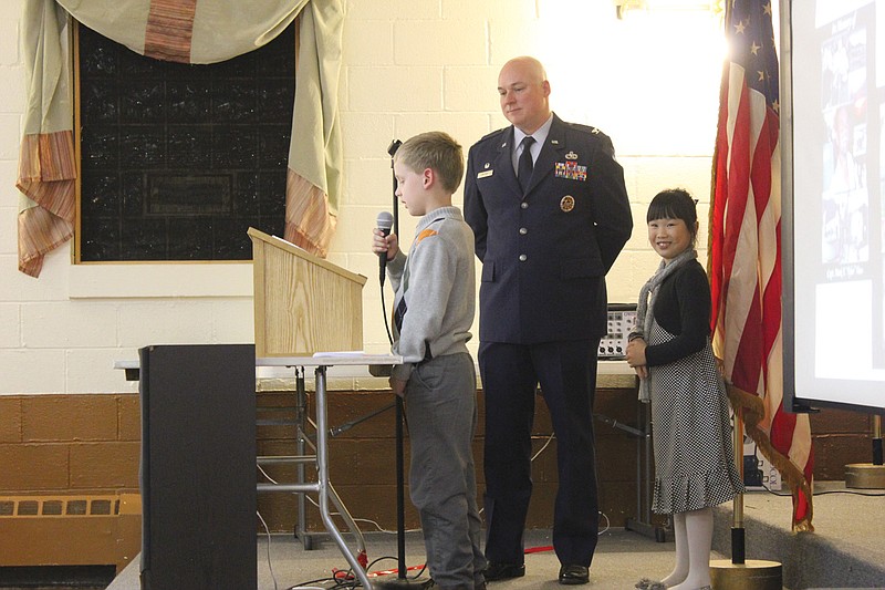 Col. Gerald McCray, center, looks on as his son Cody reads a poem and his daughter Alaina prepares to sing the Air Force theme at the Fulton VFW and American Legion's annual Veterans Day Banquet Monday. A Callaway native, McCray was invited to speak as the guest of honor.
