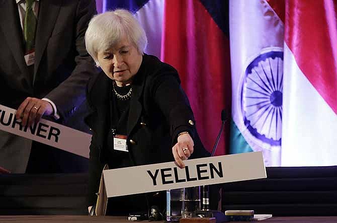 In this Monday, June 3, 2013, file photo, Janet Yellen, vice chair of the Board of Governors of the Federal Reserve System, places her name plate at her seat at the International Monetary Conference in Shanghai, China. Janet Yellen is expected to face skepticism at a hearing Wednesday, Nov. 13, 2013, on her nomination to lead the Federal Reserve from Republicans who say the Fed's policies may be swelling asset bubbles or raising the risk of high inflation. 