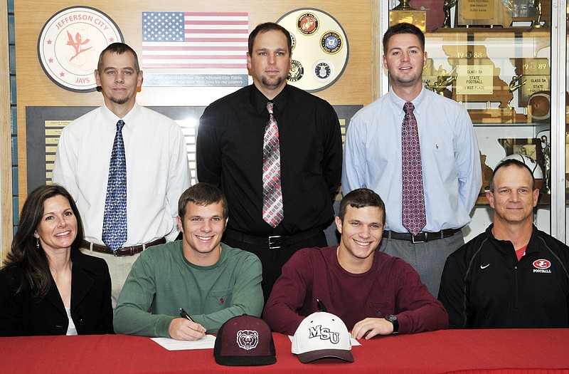 Jackson (second from left) and Jake Walker of Jefferson City High School both sign letters of intent Wednesday to play baseball at MIssouri State University. Also seated are their parents, Cindy and Terry Walker. Standing (from left) are Jays assistant coach J.R. Simmons, head coach Brian Ash and assistant coach Kyle Lasley.