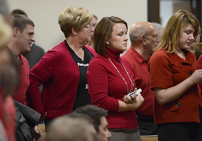 Stephanie Bell, center, stands with other supporters of the downtown site for the proposed conference center during a city council hearing on the issue Thursday evening. Proponents of the downtown site made their presence known by wearing red to show their support.