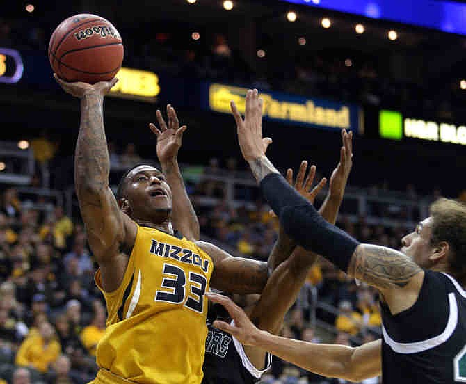 Missouri guard Earnest Ross (33) shoots against Hawaii's Keith Shamburger, back, and Isaac Fotu, right, during the first half of an NCAA college basketball game on Saturday, Nov. 16, 2013, in Kansas City, Mo. 