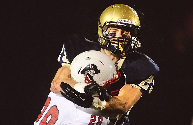 Helias linebacker Michael Tannehill wraps up a Hannibal player during Monday's game at Adkins Stadium.