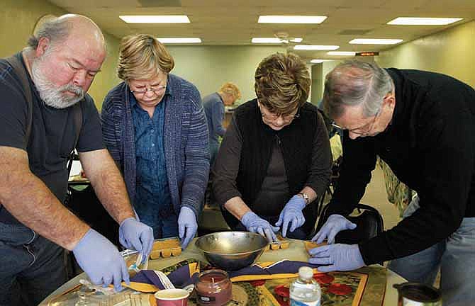 From left, John Oaks, Jeanne Oaks, Kathleen Raub and Ernie Raub pat down bird food made from Regina Garr's traditional suet dough recipe at the Cooking for the Birds seminar Saturday. The seminar was hosted by Regina and Steve Garr, owners of Birds-I-View.