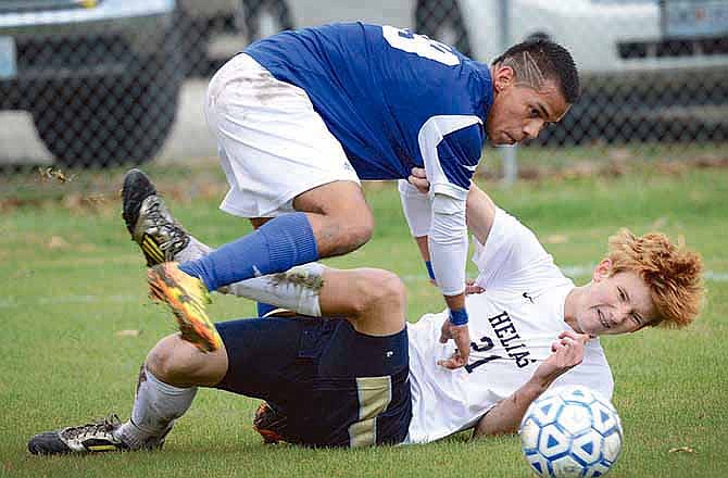 Helias defender Sam Heckart (21) and Carthage midfielder Hector Marin (19) battle for control of the ball during their Class 2 state quarterfinal Saturday at the 179 Soccer Park in Jefferson City. Carthage defeated Helias 4-0.