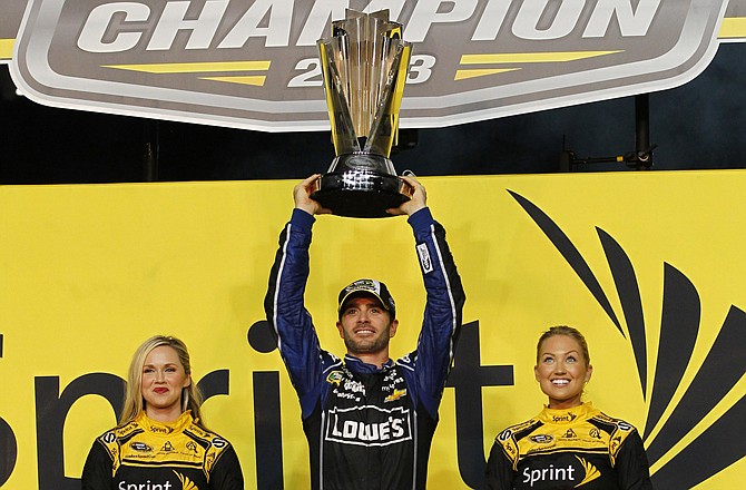 Jimmie Johnson hoists the trophy Sunday after winning his sixth Sprint Cup title.