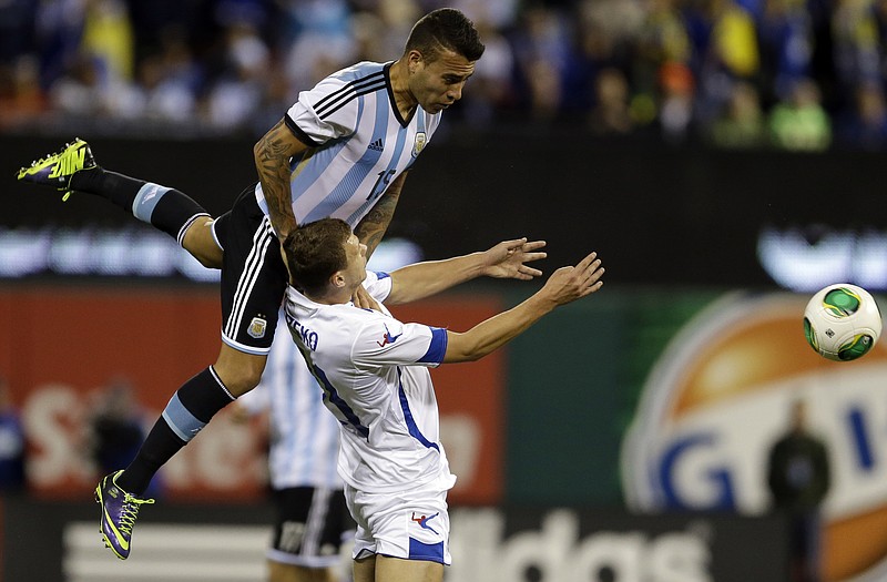 Argentina's Nicolas Otamendi (top) heads the ball away from Bosnia's Edin Dzeko during the first half of Monday's international friendly in St. Louis.