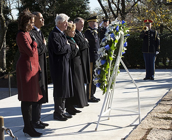 President Barack Obama, first lady Michelle Obama, former President Bill Clinton and his wife former Secretary of State Hillary Rodham Clinton, along with members of the Kennedy family, pause Wednesday during a wreath laying ceremony in honor of President John F. Kennedy, at Arlington National Cemetery in Arlington, Va. Friday will mark the 50th anniversary of the Kennedy assassination.