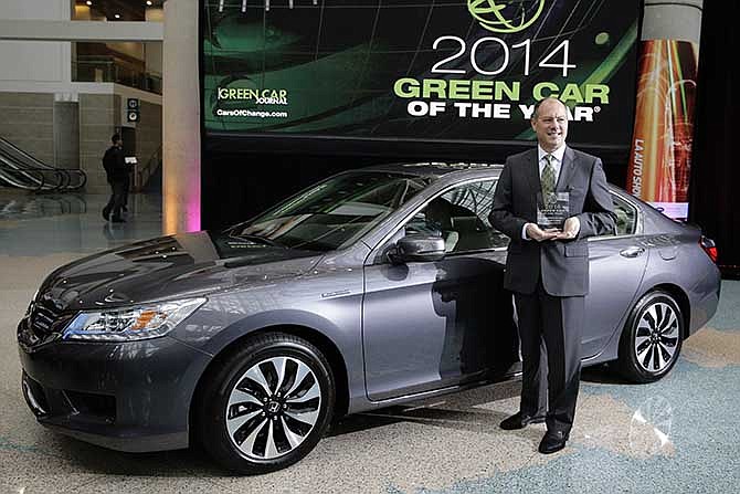 Mike Accavitti, senior vice president of automobile operations at American Honda, poses for photos in front of the 2014 Honda Accord hybrid sedan at the Los Angeles Auto Show on Thursday, Nov. 21, 2013, in Los Angeles. The 2014 Honda Accord is named the Green Car of the Year.