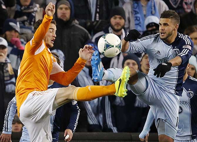 Houston defender Eric Brunner, left, and Sporting KC forward Dom Dwyer, right, battle for the ball during the second half of an MLS playoff soccer match in Kansas City, Kan., Saturday, Nov. 23, 2013. Sporting KC defeated Houston Dynamo 2-1.