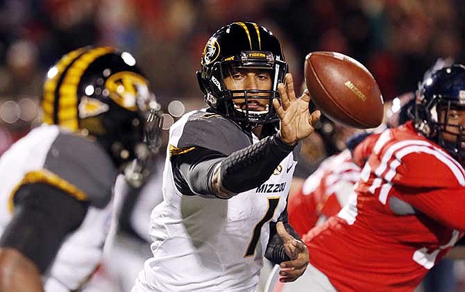 Missouri quarterback James Franklin (1) pitches out to Missouri running back Marcus Murphy for short yards against Mississippi during the first half of an NCAA college football game Saturday, Nov. 23, 2013, in Oxford, Miss. 