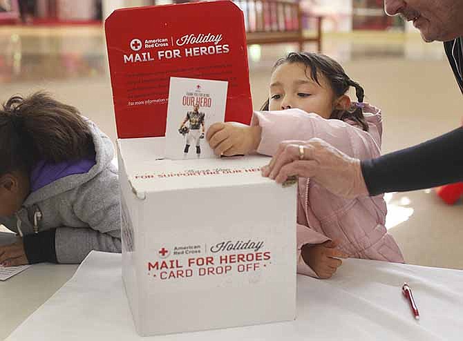 Gabby Boucher, 5, finishes a Christmas card she wrote to a U.S. service member Saturday as part of the Red Cross Holiday Mail for Heroes card signing at Capital Mall in Jefferson City. The cards are sent to American military, veterans hospitals and other locations.