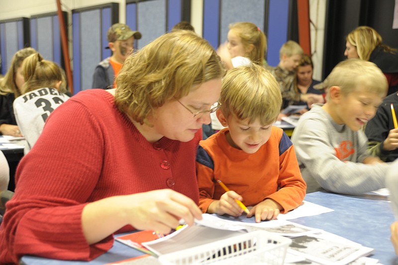 Tagging along with his older siblings, Isaac Epema, 4, enjoyed the sight word search activity with his mom Katie Tuesday at Cole County R-1 Elementary School's Literacy Night. News Tribune photo/Michelle Brooks