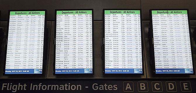 Departure boards display dozens of canceled flights Monday in terminal D at Dallas-Fort Worth International airport. Winter weather has caused travel disruptions throughout the area, and storms are expected to continue to cause problems for holiday travelers.