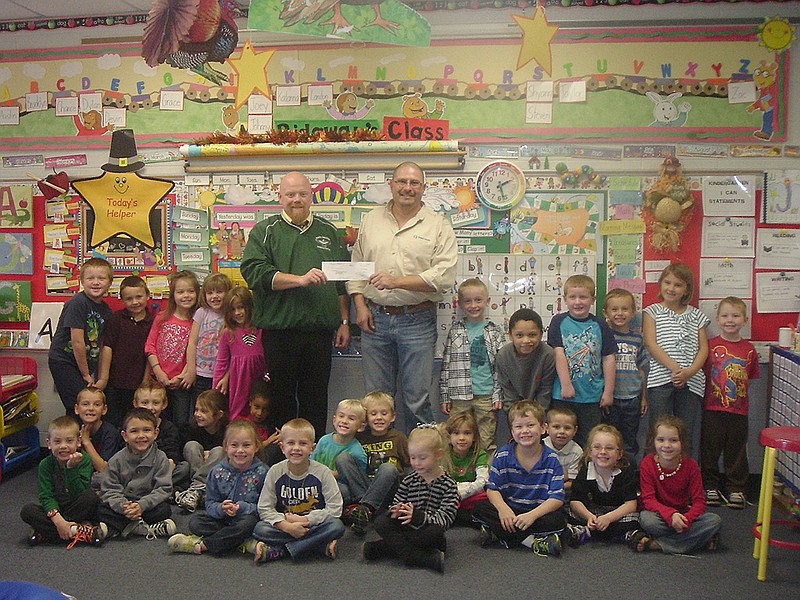 Hatton-McCredie Elementary Principal Brian Jobe and the kindergarten class receive a $2,000 partnership check from TransCanada's Roughy McCoy on behalf of the school. The donation will be used to purchase additional security cameras for the school's Safe Release Program.