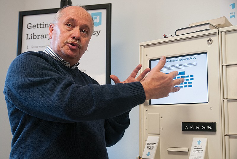 Mike Mullet, IT manager for the Daniel Boone Regional Library, demonstrates how to use the Library-To-Go system at the new Holts Summit city hall on Tuesday during the facility's open reception. The Library-To-Go system was one of the new features unveiled during the city's ribbon cutting and open house for its new city hall building Tuesday, Nov. 26. Mullet was one of the main developers of the system. The Library-To-Go hours are Monday through Friday from 8 a.m. to 7 p.m. and Saturday and Sunday from 8 a.m. to 10 p.m. The Holts Summit received the Library-To-Go system because of citizens' frequent use of the library and bookmobile. "We hope we get a new boat load of people who get library cards (in Holts Summit)," Mullet said.