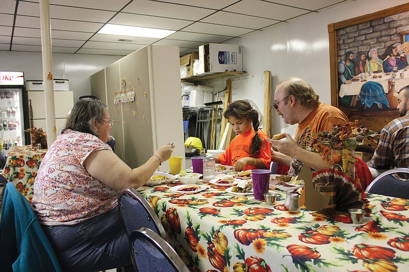 From left: Lisa Hardin, 7-year-old Brittany Reed and Dale Dietsch sit down for a Thanksgiving meal Thursday at New Bloomfield United Methodist Church. The annual Community Thanksgiving Dinner, which organizer Tom Levin has hosted for eight years, continued to draw people from across mid-Missouri who weren't able to host or attend a meal on their own.