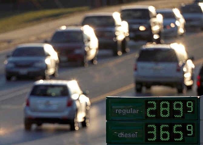 Motorists drive past a gas station selling regular unleaded gasoline for less than $3.00 a gallon Tuesday, Nov. 26, 2013, in Independence, Mo. The average price of gasoline in the U.S. has tumbled 49 cents from their peak this year to $3.29 a gallon, putting shoppers on track to have the lowest prices at the pump since 2010, according to AAA.