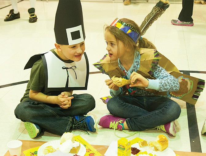 Colten Haskell, 6, dressed like a pilgrim, leans in to listen to his classmate, Myah Briggs, dressed like a Native American, during the New Bloomfield kidergarten Thanksgiving feast on Tuesday. 
