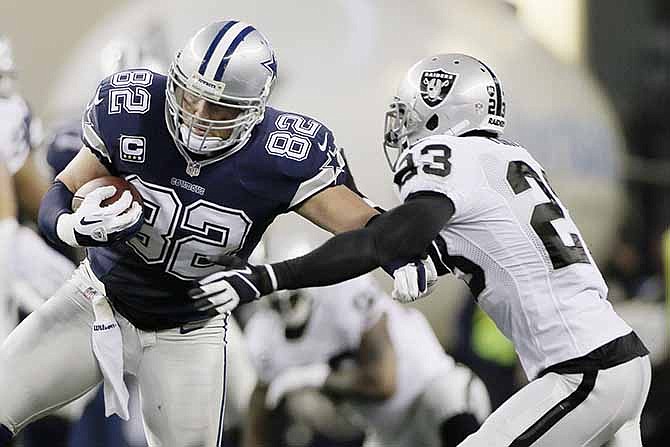 Dallas Cowboys tight end Jason Witten (82) is tackled by Oakland Raiders cornerback Tracy Porter (23) during the first half of an NFL football game, Thursday, Nov. 28, 2013, in Arlington, Texas. 