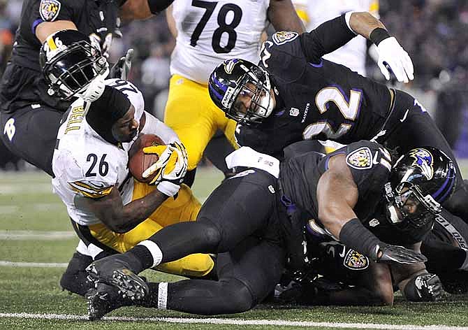 Pittsburgh Steelers running back Le'Veon Bell (26) loses his helmet after a collision as he tries to score a touchdown in the second half of their game against the Baltimore Ravens, Thursday, Nov. 28, 2013, in Baltimore. Bell left the field with an injury after the run, which fell short of the goal line because, by rule, losing his helmet ended the play.