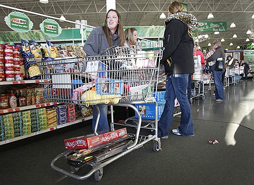 Rachael Connell moves through the check-out line Friday morning at the Menards Black Friday sale with her sisters and mother. Connell and her family drove in from Slater. for the holiday and began their Black Friday shopping at 4:30 p.m. the day before.