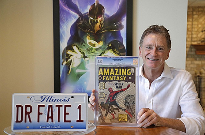 Steve Landman shows off one of his collectible comic books, a vanity license plate with the name of a childhood superhero on it, and a poster of the same superhero Dr. Fate, at his home in Kildeer, Ill.