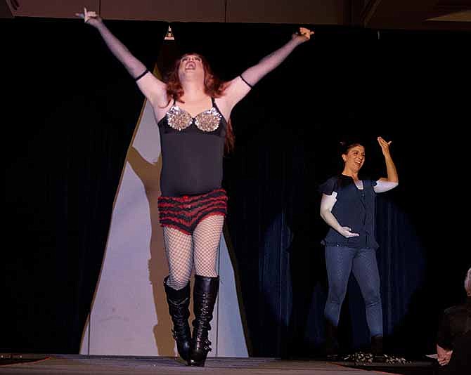 In this Nov. 22, 2013, photo, Holly Maniatty, right, an American Sign Language interpreter, signs during a performance by a contestant in the the Royal Majesty Drag Show and Competition in Portland, Maine. Maniatty has worked with several big-names performers such as Wu Tang Clan, Jay-Z, and Phish. 