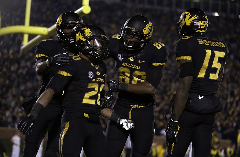 Missouri running back Henry Josey (20) is congratulated by Tiger teammates after scoring on a 57-yard run in the fourth quarter of Saturday night's game against Texas A&M at Faurot Field.