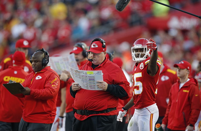 Chiefs head coach Andy Reid looks at a play chart during Sunday's game against the Broncos at Arrowhead Stadium.