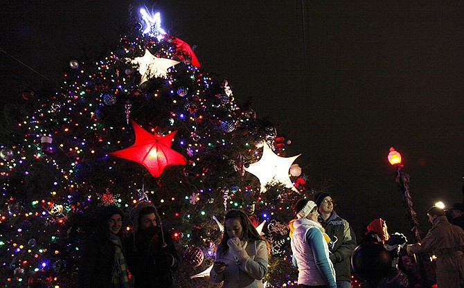 People gather around the Mayor's Christmas Tree after the eighth annual lighting ceremony in Rotary Centennial Park on Thursday evening. The lighting kicks off a weekend of holiday activities.