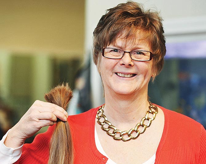 Tina Sellner holds up her just-shorn hair that she'll send in for use in wigs for cancer patients. She's been growing it for more than two years and wanted to donate it in honor of her sister who died from cancer and to celebrate friends who have survived their battle with the disease.