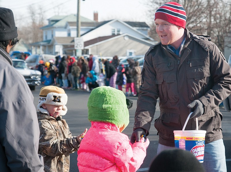 Travis Fitzwater, of Holts Summit, hands out candy and informs people he is running for Missouri's 49th district in the state House of Representatives during the annual Fulton Jaycees Christmas Parade on Saturday. 