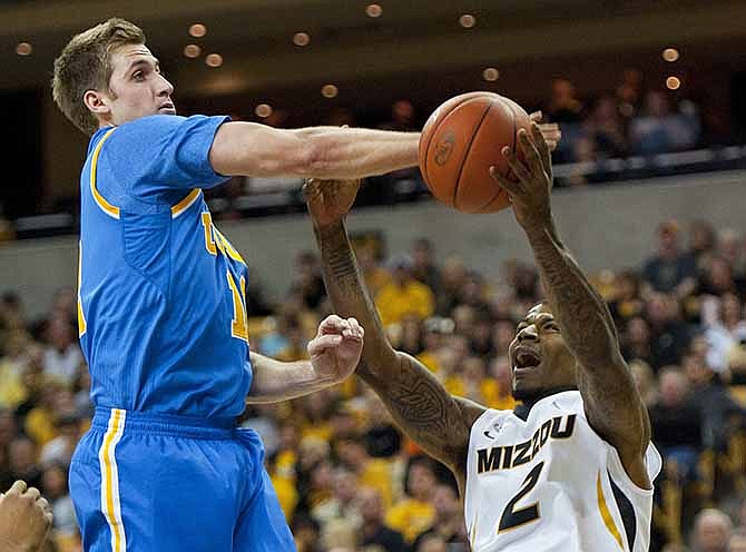UCLA's David Wear, left, fouls Missouri's Tony Criswell, right, as he tries to shoot during the first half of an NCAA college basketball game Saturday, Dec. 7, 2013, in Columbia, Mo.