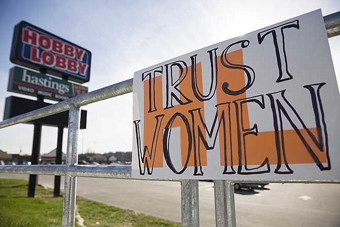 NOW members placed a sign on display urging Hobby Lobby to "trust women" as part of a picket outside the Jefferson City store Saturday.