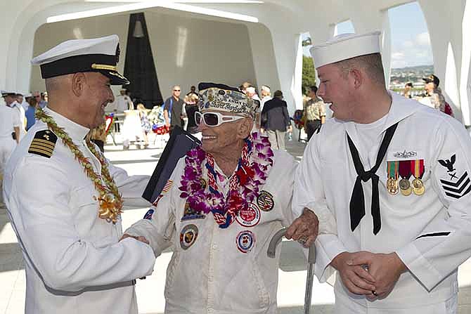 Navy chaplain Sal Aguliera, left, shares a moment with Pearl Harbor survivor Allen Bodenlos, center, who is being escorted by Navy petty officer Michael Temple aboard the USS Arizona Memorial during the ceremony commemorating the 72nd anniversary of the attack on Pearl Harbor, Saturday, Dec. 7, 2013, in Honolulu.